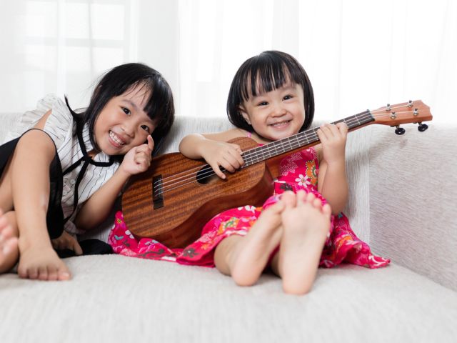 Asian Chinese little sister playing ukele